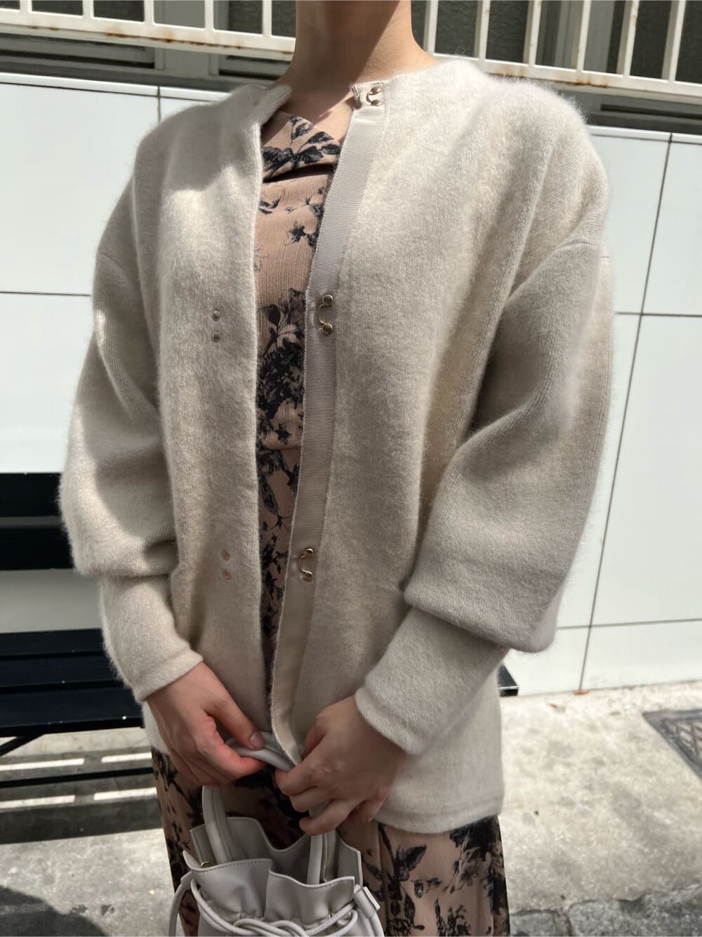 レッド系のブーツ、ホワイト系のカーディガン/ボレロ、ホワイト系のハンドバッグを着用したレディースの秋コーディネートの4枚目の写真