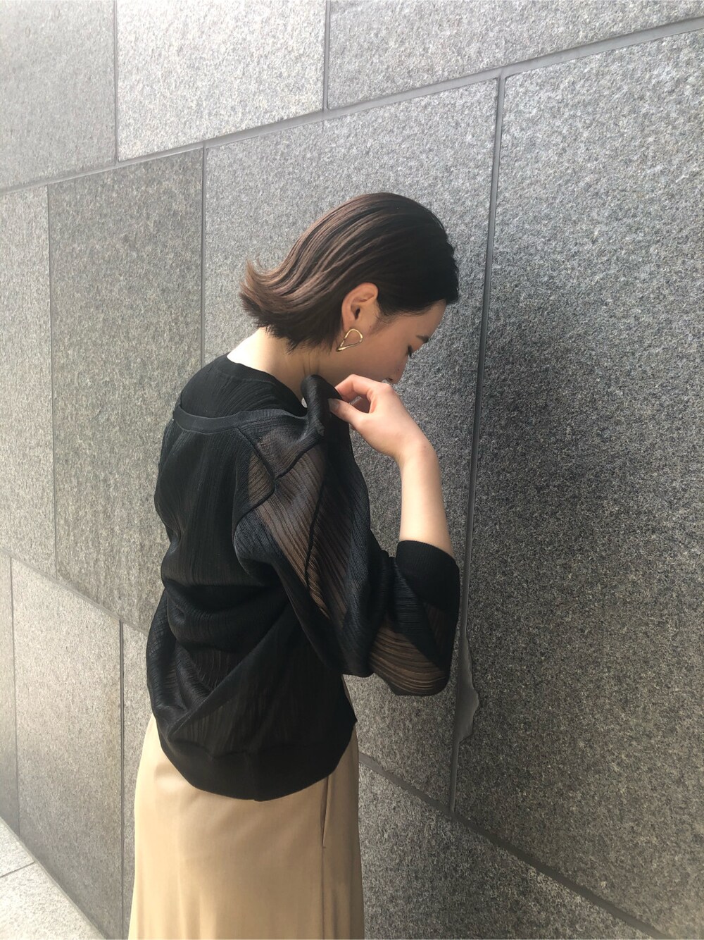 ブラック系のニット/セーター、ブラウン系のパンプス、パープル系のハンドバッグを着用したレディースの春コーディネートの4枚目の写真