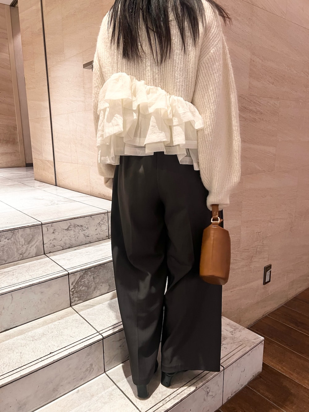 ホワイト系のニット/セーター、グレー系のその他パンツ、イエロー系のハンドバッグを着用したレディースの冬コーディネートの6枚目の写真