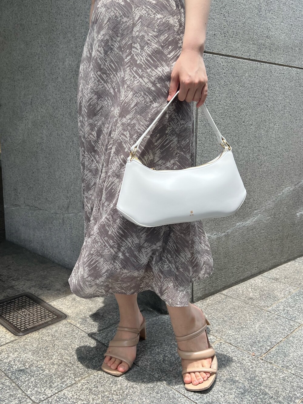 ホワイト系のハンドバッグ、ベージュ系のサンダル、グレー系のワンピースを着用したレディースの夏コーディネートの7枚目の写真