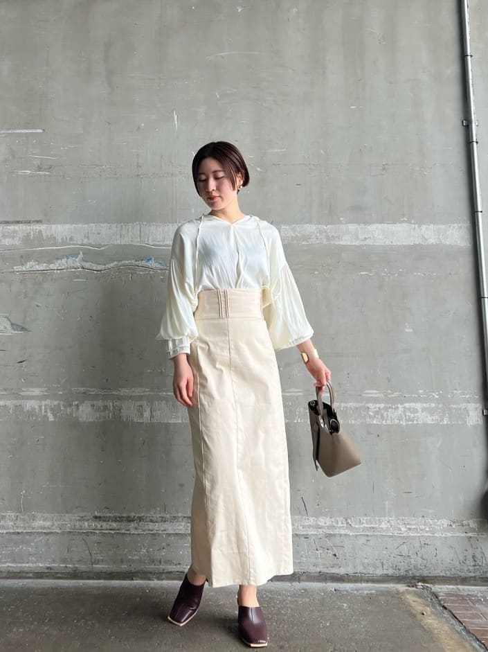 ベージュ系のハンドバッグ、ホワイト系のシャツ/ブラウス、レッド系のサンダルを着用したレディースの春コーディネートの3枚目の写真