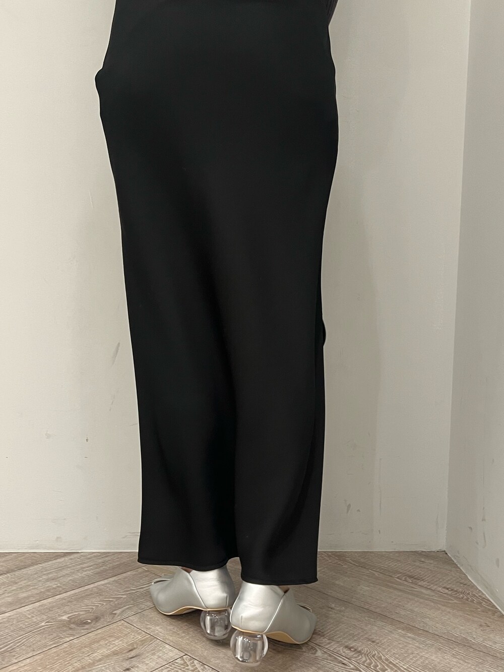 ブラック系のハンドバッグ、シルバー系のパンプス、ブラック系のワンピースを着用したレディースの冬コーディネートの7枚目の写真