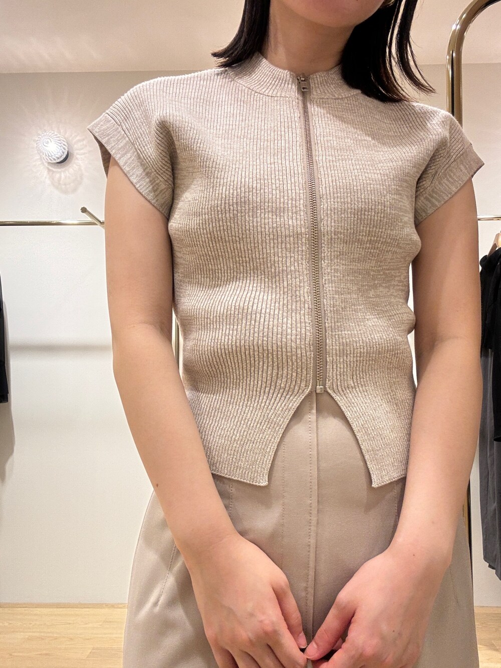 シルバー系のパンプス、ベージュ系のニット/セーター、レッド系のショルダーバッグを着用したレディースの秋コーディネートの4枚目の写真