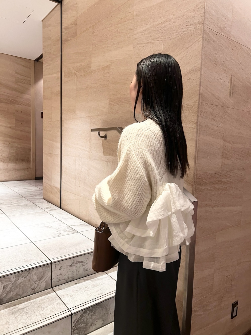 ホワイト系のニット/セーター、グレー系のその他パンツ、イエロー系のハンドバッグを着用したレディースの冬コーディネートの3枚目の写真