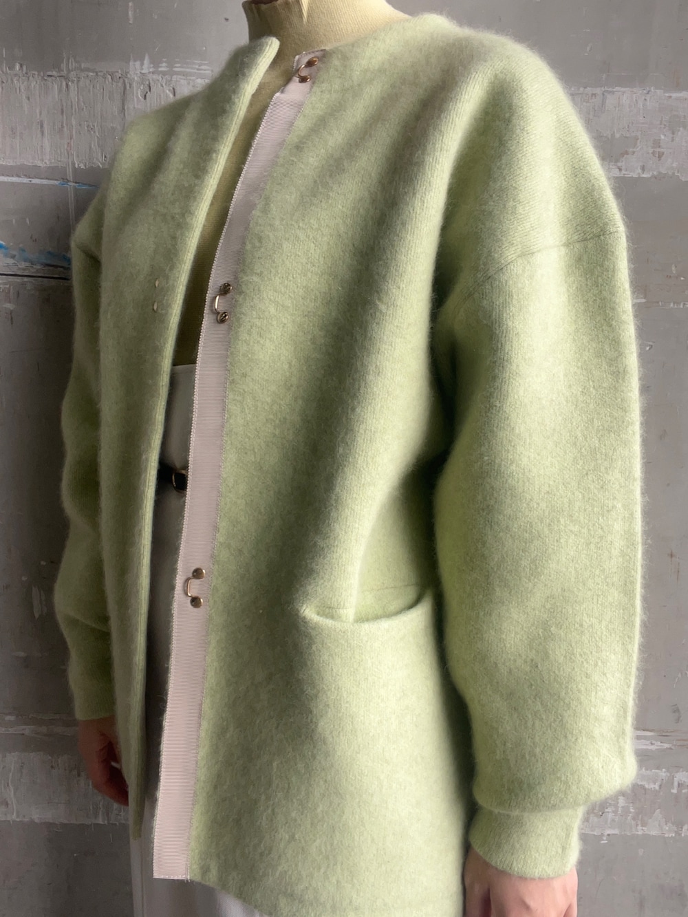 ベージュ系のブーツ、イエロー系のニット/セーター、グリーン系のカーディガン/ボレロを着用したレディースの秋コーディネートの2枚目の写真