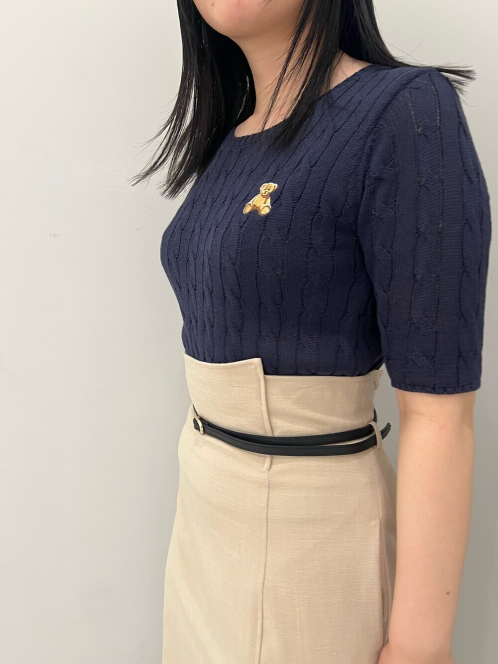 ブルー系のニット/セーター、ホワイト系のサンダル、ベージュ系のスカートを着用したレディースの春コーディネートの5枚目の写真