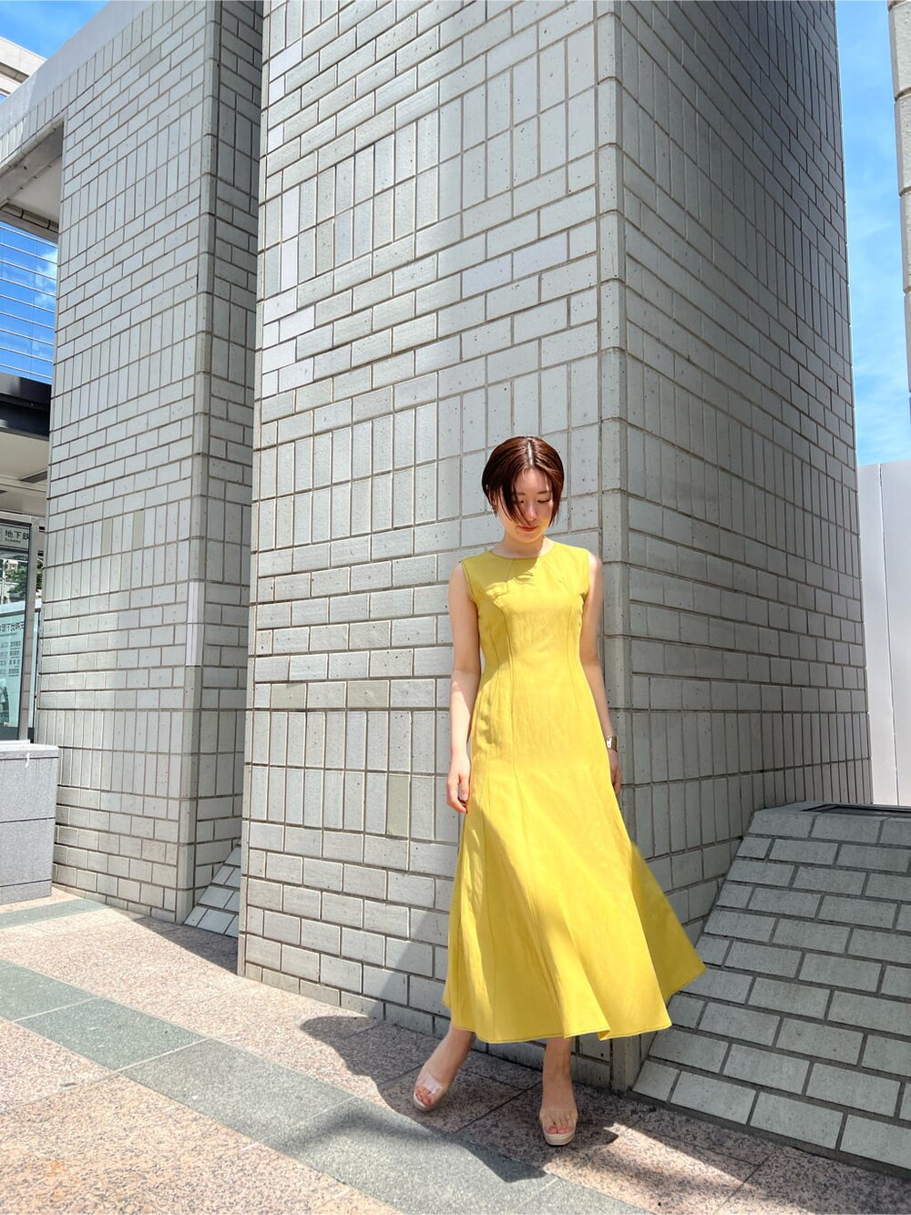 その他のパンプス、イエロー系のワンピース、ゴールド系のバングル/リストバンドを着用したレディースの春コーディネートの6枚目の写真