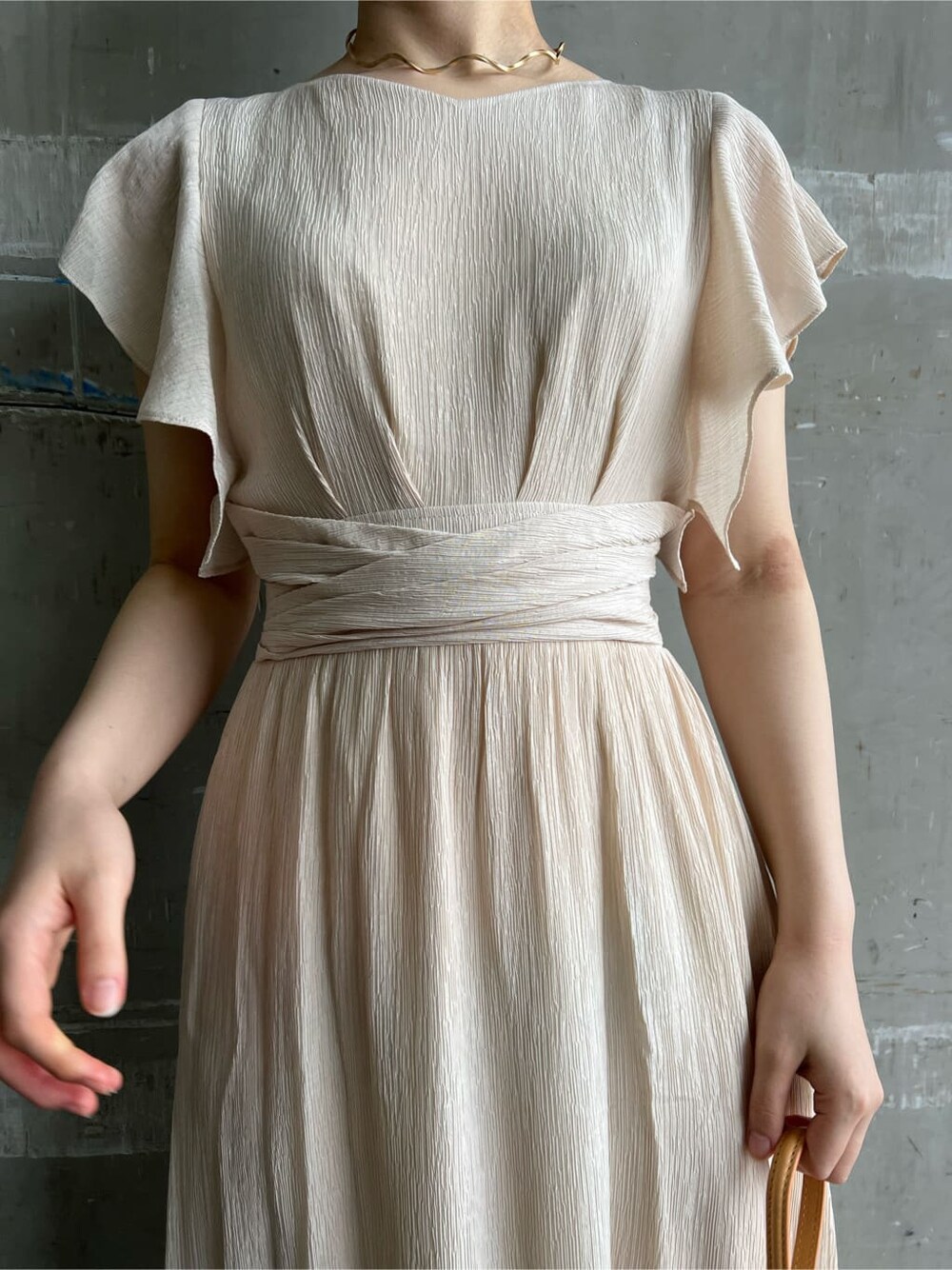 ホワイト系のワンピース、ブラウン系のパンプス、オレンジ系のショルダーバッグを着用したレディースの春コーディネートの7枚目の写真