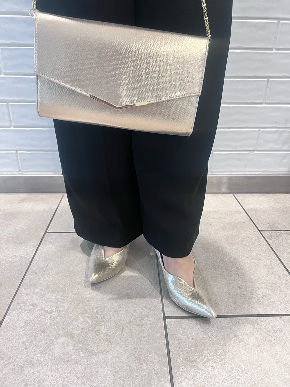 その他のパンツドレス、ゴールド系のパンプス、ゴールド系のクラッチバッグを着用したレディースの春コーディネートの9枚目の写真