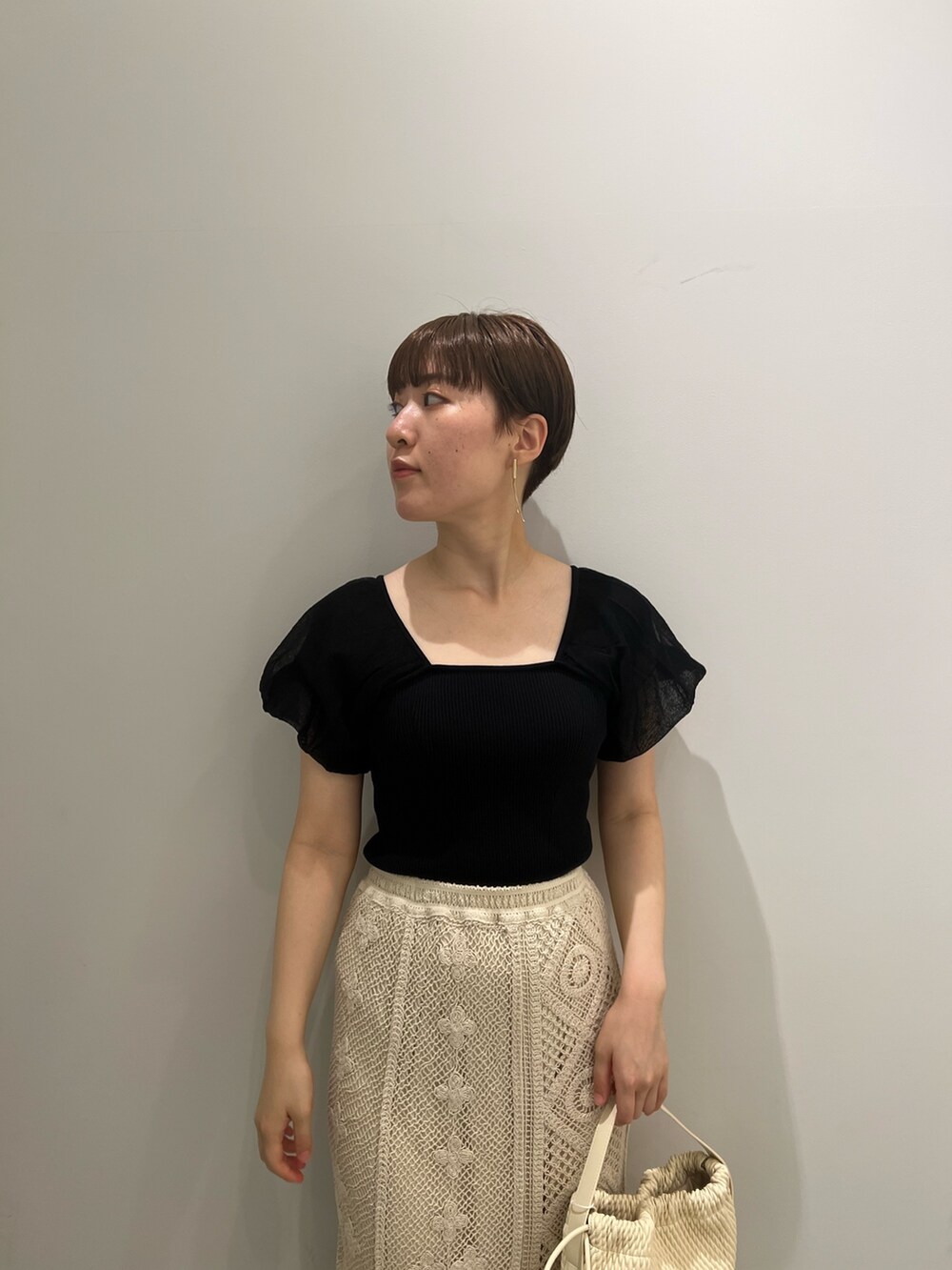 ベージュ系のサンダル、ホワイト系のスカート、ホワイト系のハンドバッグを着用したレディースの夏コーディネートの4枚目の写真