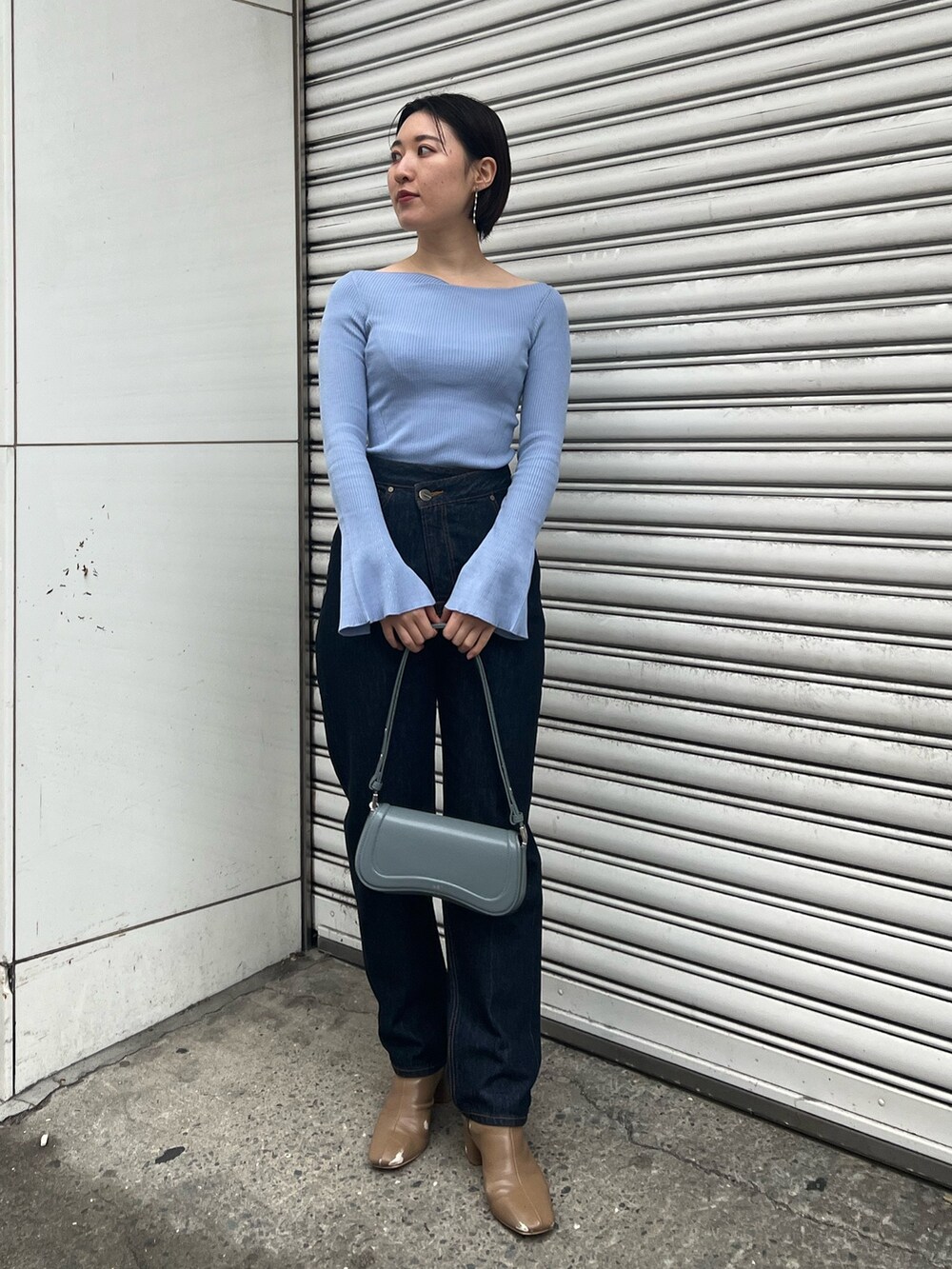 ブルー系のショルダーバッグ、ブルー系のニット/セーター、ベージュ系のブーツを着用したレディースの冬コーディネートの7枚目の写真