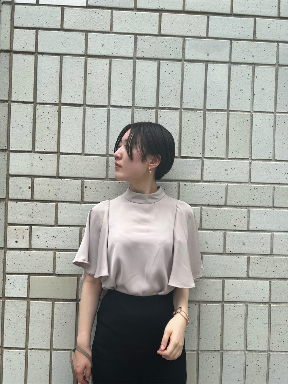 ベージュ系のハンドバッグ、グリーン系のサンダル、ブラック系のスカートを着用したレディースの夏コーディネートの4枚目の写真