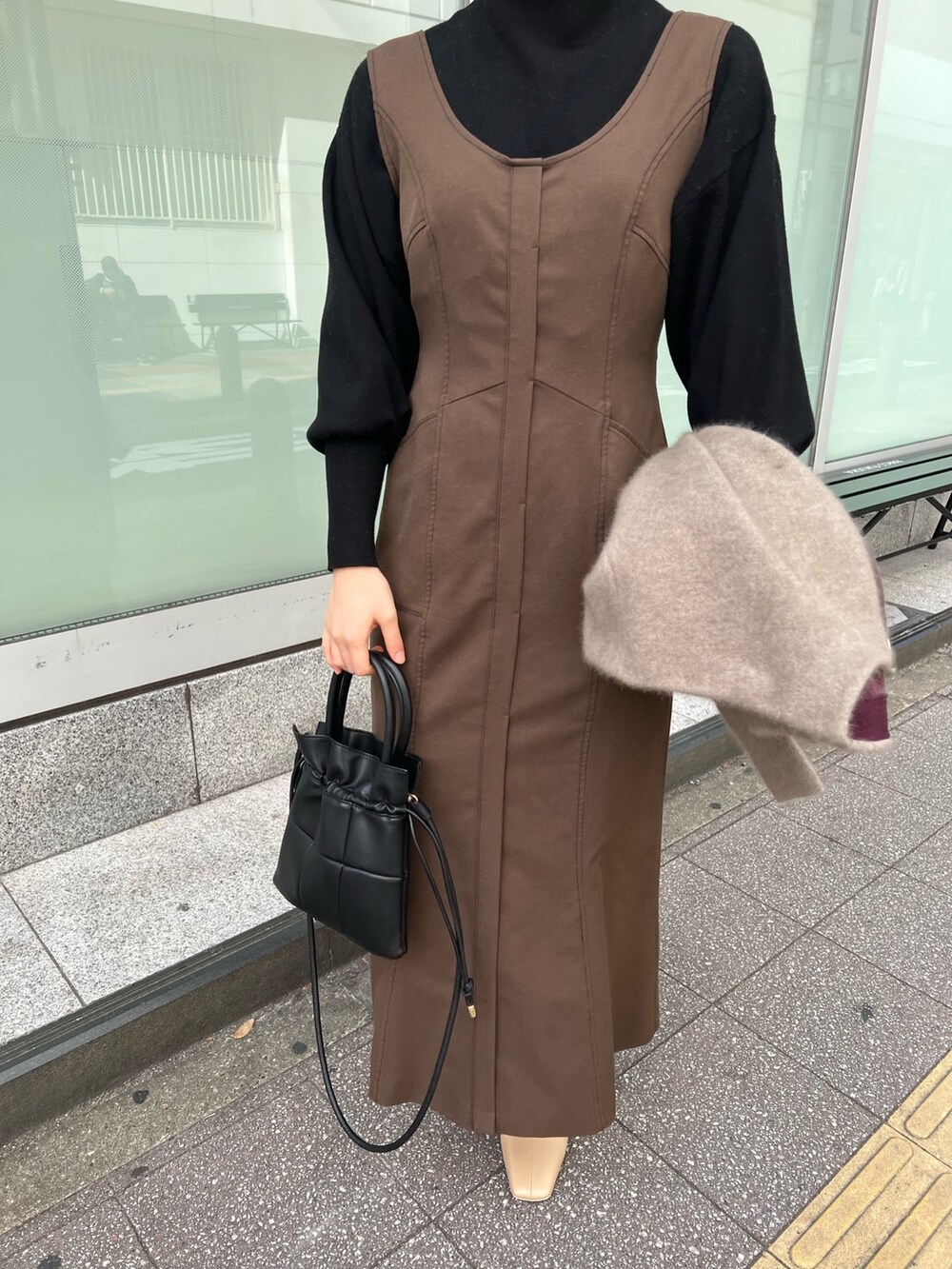 ブラック系のハンドバッグ、ベージュ系のブーツ、ベージュ系のカーディガン/ボレロを着用したレディースの秋コーディネートの7枚目の写真