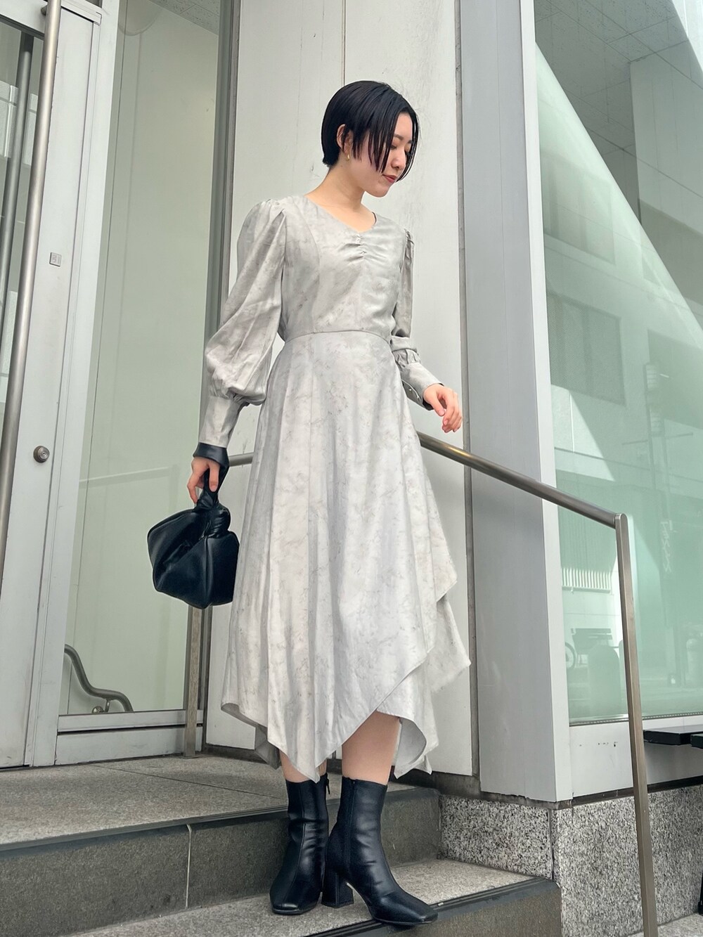 グレー系のカーディガン/ボレロ、グレー系のワンピース、ブラック系のブーツを着用したレディースの秋コーディネートの4枚目の写真