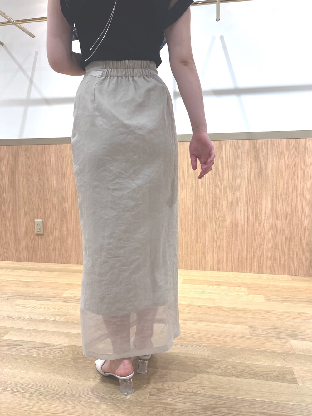 ブラック系のニット/セーター、ホワイト系のスカート、ホワイト系のサンダルを着用したレディースの春コーディネートの9枚目の写真