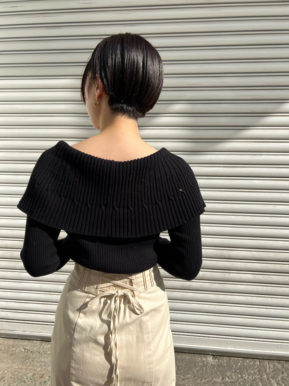 レッド系のブーツ、ホワイト系のスカート、ホワイト系のカーディガン/ボレロを着用したレディースの冬コーディネートの6枚目の写真