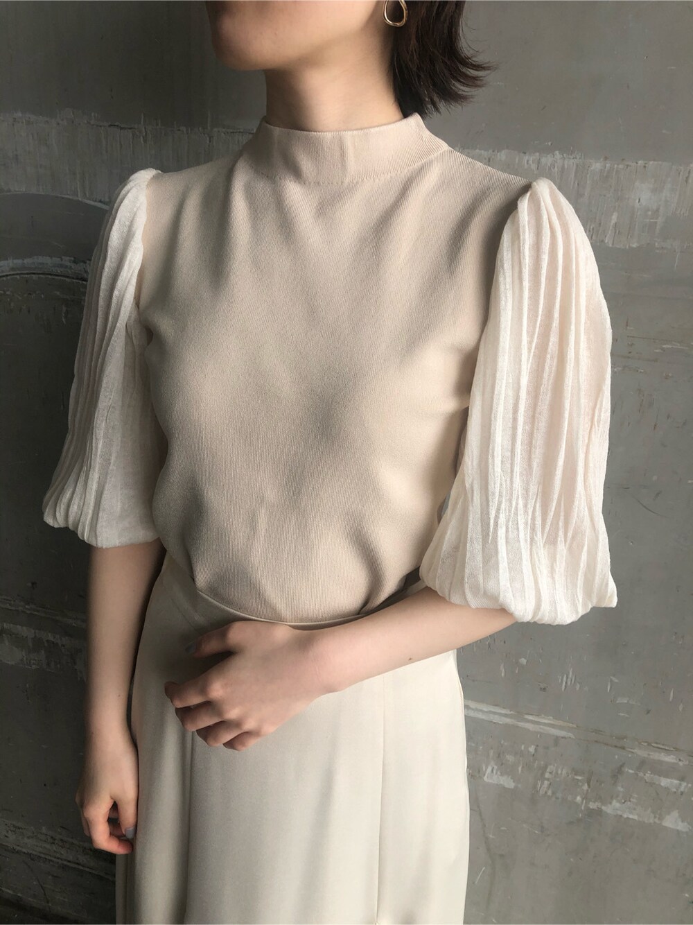 ホワイト系のスカート、ブラウン系のパンプス、ベージュ系のその他アウターを着用したレディースの春コーディネートの6枚目の写真