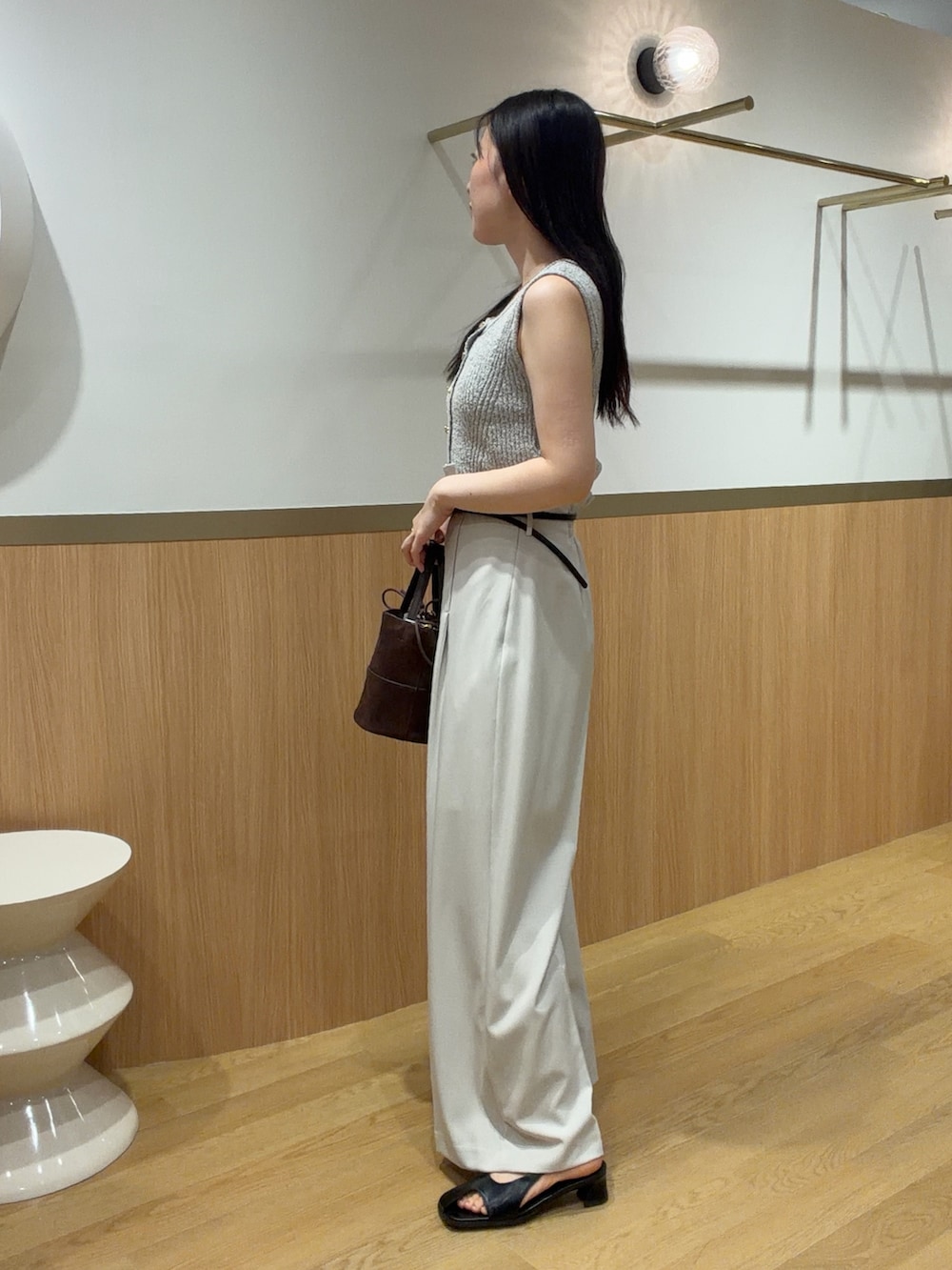 ベージュ系のニット/セーター、ホワイト系のその他パンツ、ブラック系のサンダルを着用したレディースの春コーディネートの3枚目の写真