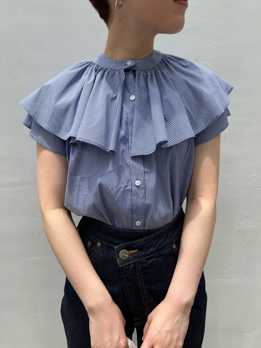 ベージュ系のサンダル、ホワイト系のショルダーバッグ、ブルー系のデニムパンツを着用したレディースの夏コーディネートの3枚目の写真