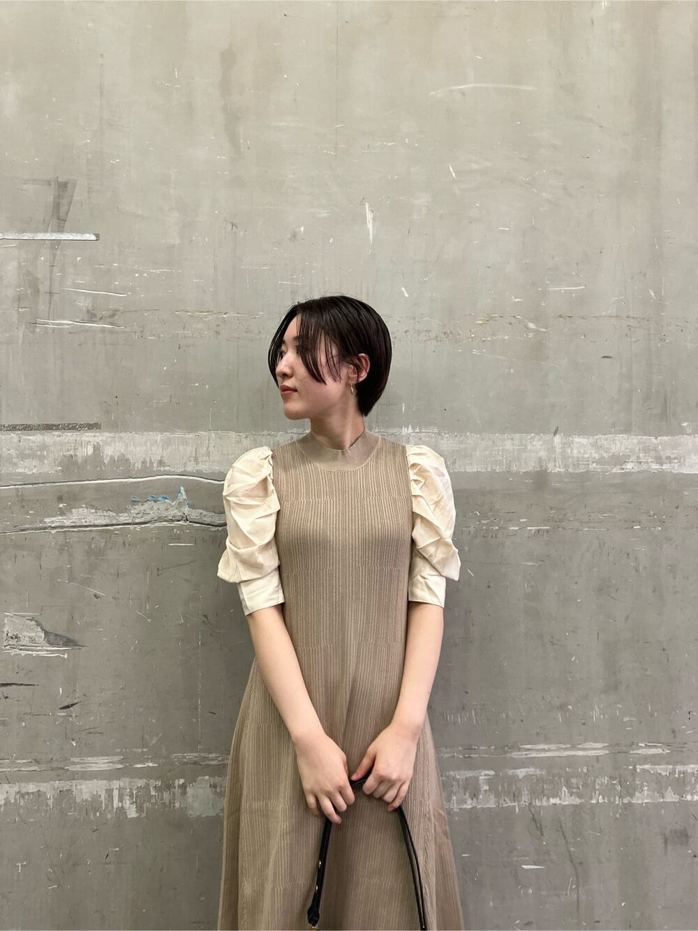 ベージュ系のワンピース、ベージュ系のブーツ、ブラック系のショルダーバッグを着用したレディースの夏コーディネートの4枚目の写真