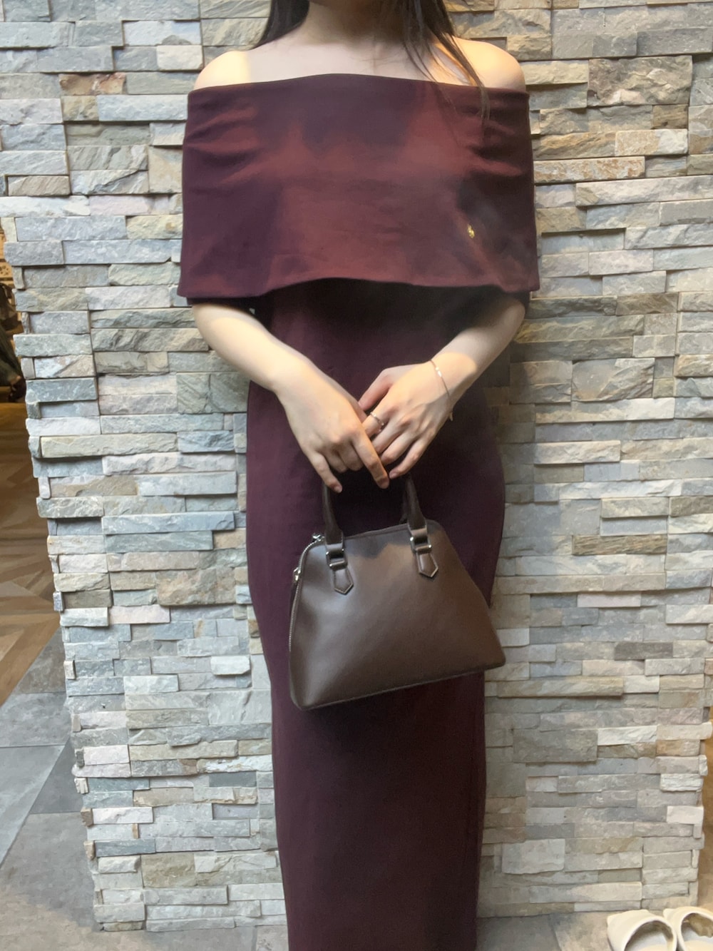 ブラウン系のボストンバッグ、ブラウン系のワンピース、ブラック系のブーツを着用したレディースの夏コーディネートの4枚目の写真