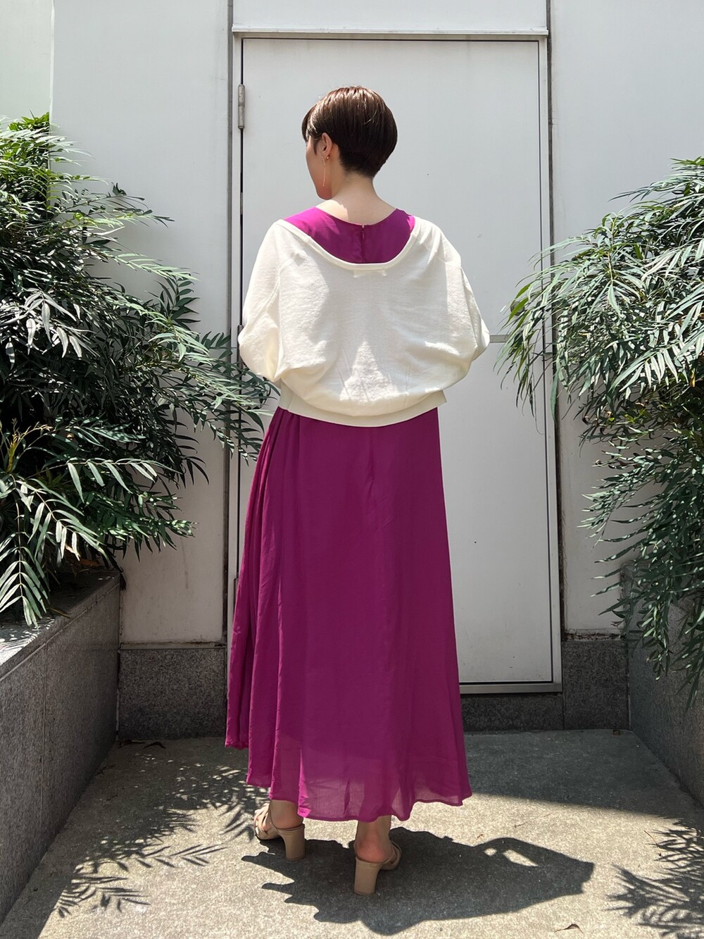 ベージュ系のサンダル、ホワイト系のハンドバッグ、パープル系のワンピースを着用したレディースの夏コーディネートの2枚目の写真