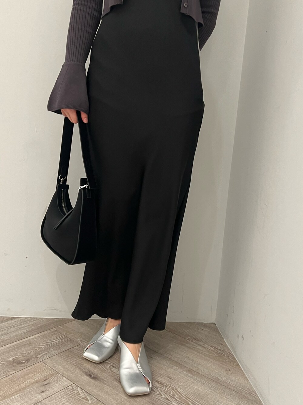 ブラック系のハンドバッグ、シルバー系のパンプス、ブラック系のワンピースを着用したレディースの冬コーディネートの5枚目の写真