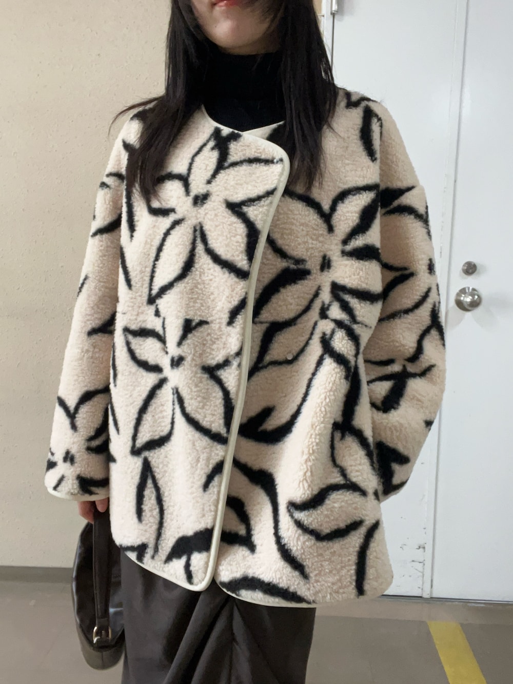 ブラック系のブーツ、ホワイト系のブルゾン、ブラック系のニット/セーターを着用したレディースの秋コーディネートの4枚目の写真