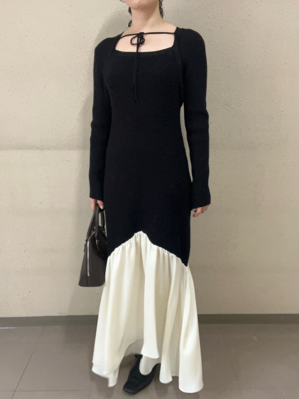 ブラック系のワンピース、ブラック系のブーツを着用したレディースの冬コーディネートの5枚目の写真