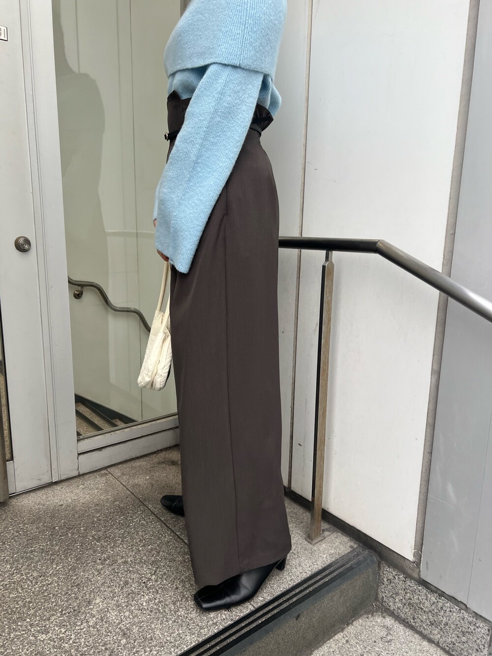 ブルー系のニット/セーター、グレー系のその他パンツ、ブラック系のブーツを着用したレディースの秋コーディネートの7枚目の写真