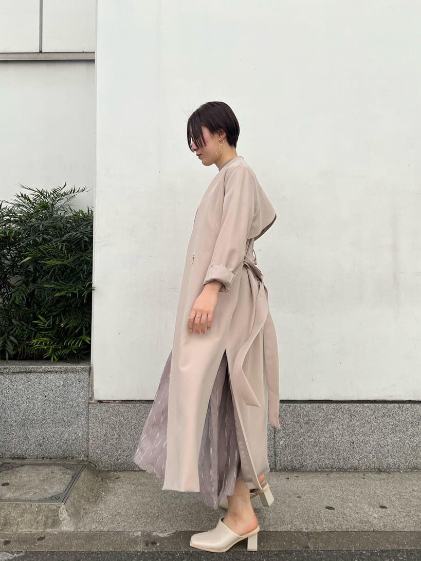 ホワイト系のノーカラーコート、グレー系のワンピース、ホワイト系のサンダルを着用したレディースの冬コーディネートの7枚目の写真