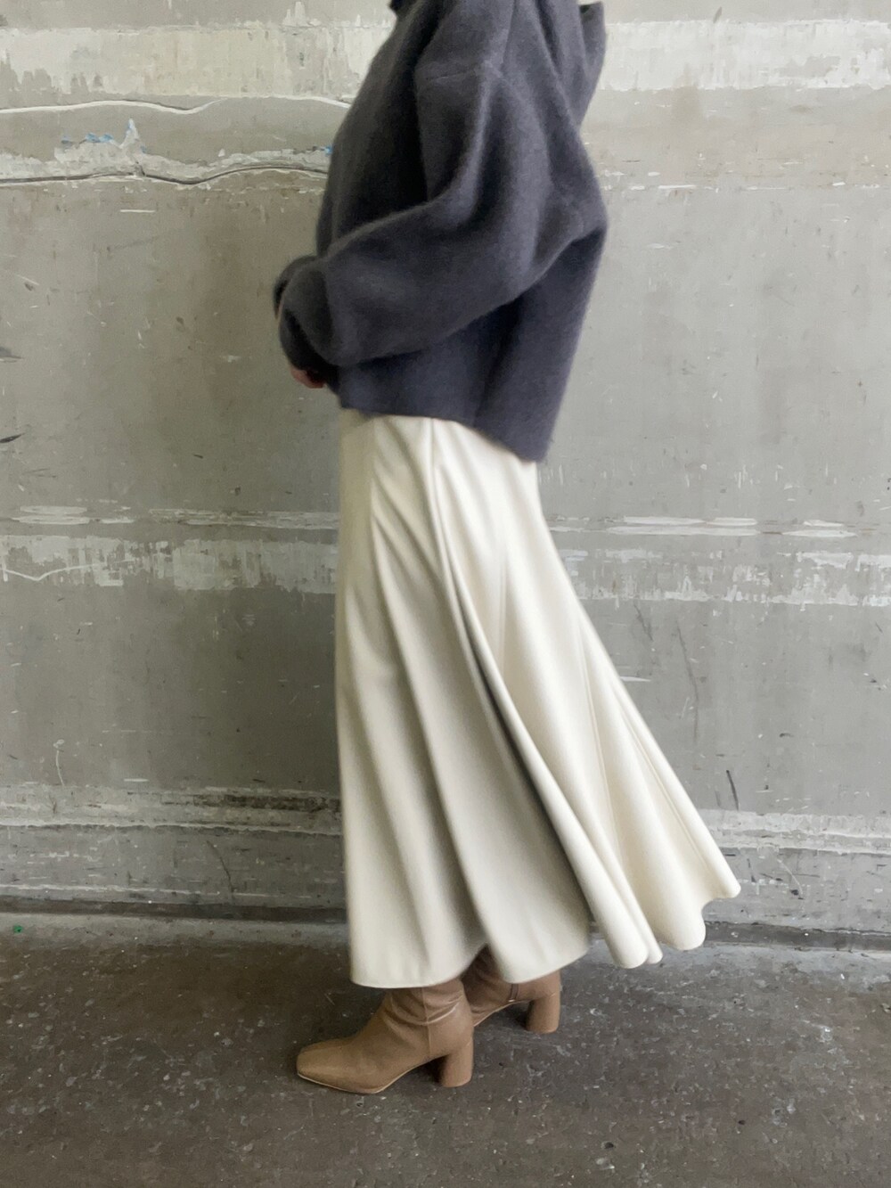 ベージュ系のブーツ、グレー系のパーカー、ホワイト系のスカートを着用したレディースの秋コーディネートの8枚目の写真