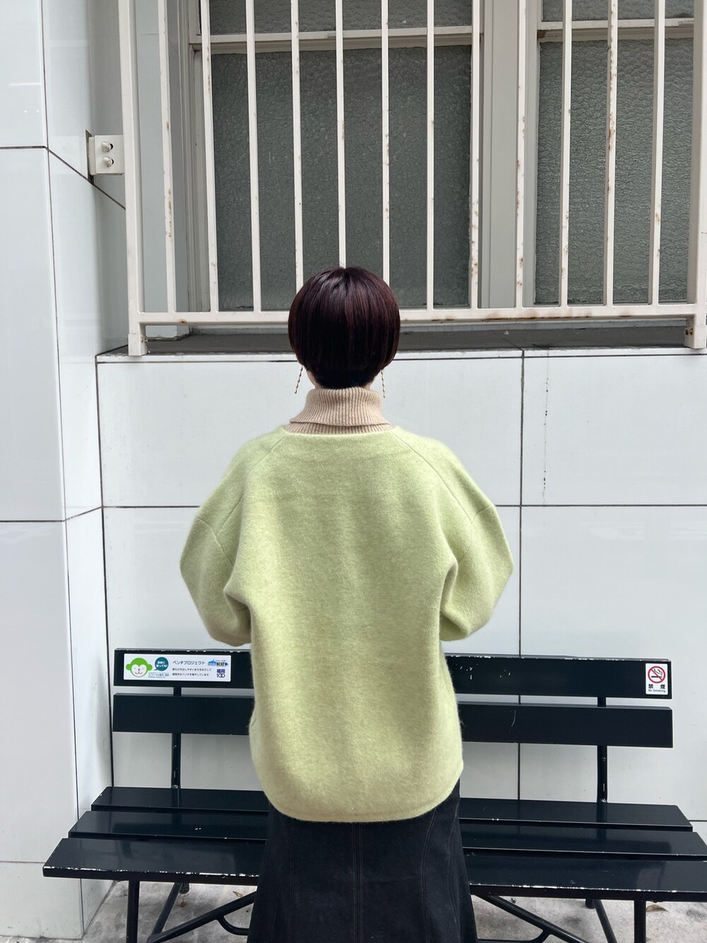 ベージュ系のスニーカー、グリーン系のカーディガン/ボレロ、ブラック系のデニムスカートを着用したレディースの秋コーディネートの4枚目の写真