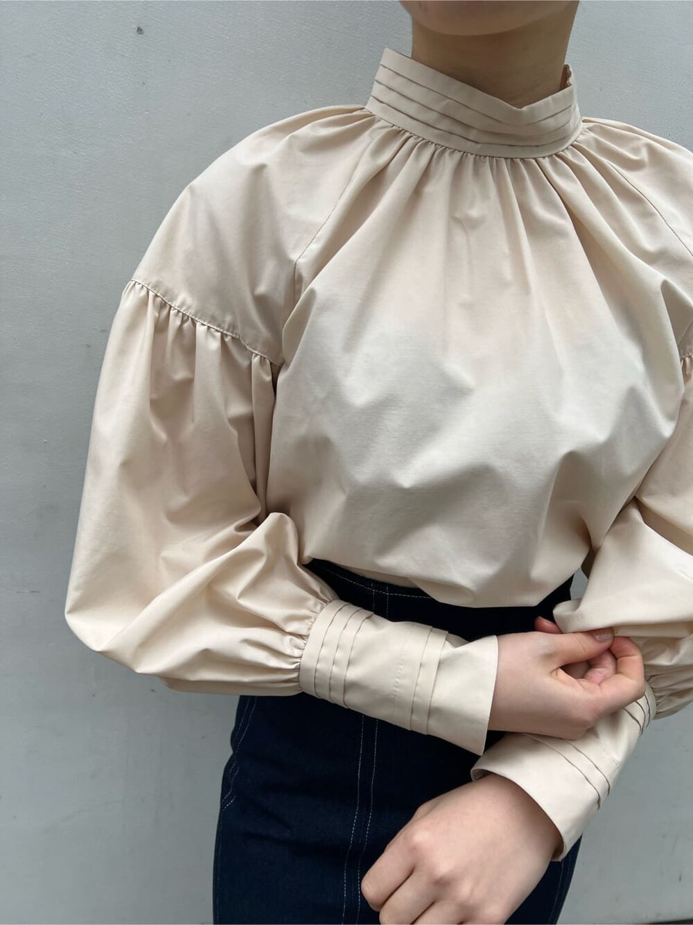 ベージュ系のシャツ/ブラウス、ベージュ系のブーツ、ブルー系のスカートを着用したレディースの春コーディネートの5枚目の写真