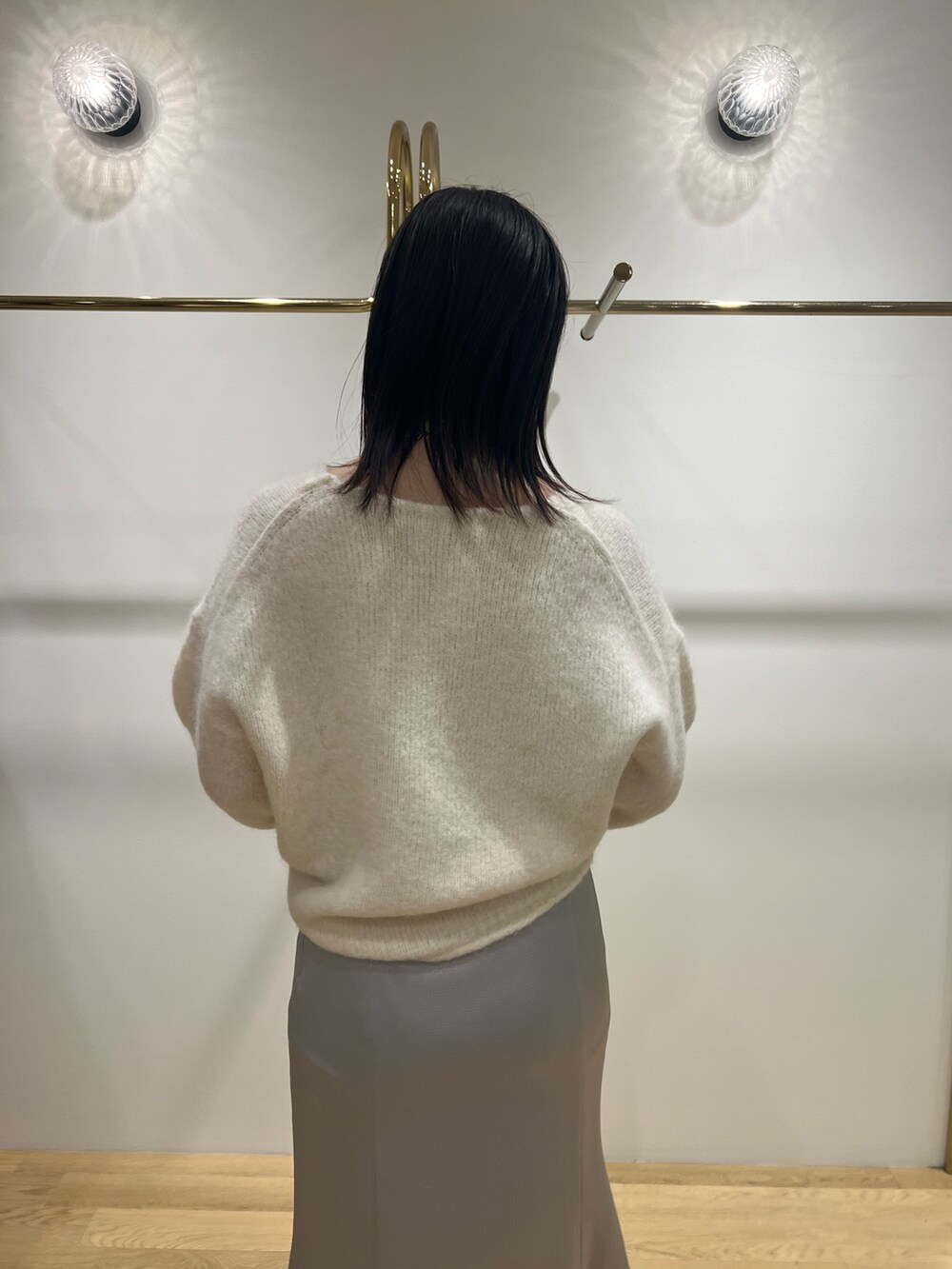 ホワイト系のニット/セーター、グレー系のブルゾン、ブラック系のブーツを着用したレディースの冬コーディネートの5枚目の写真