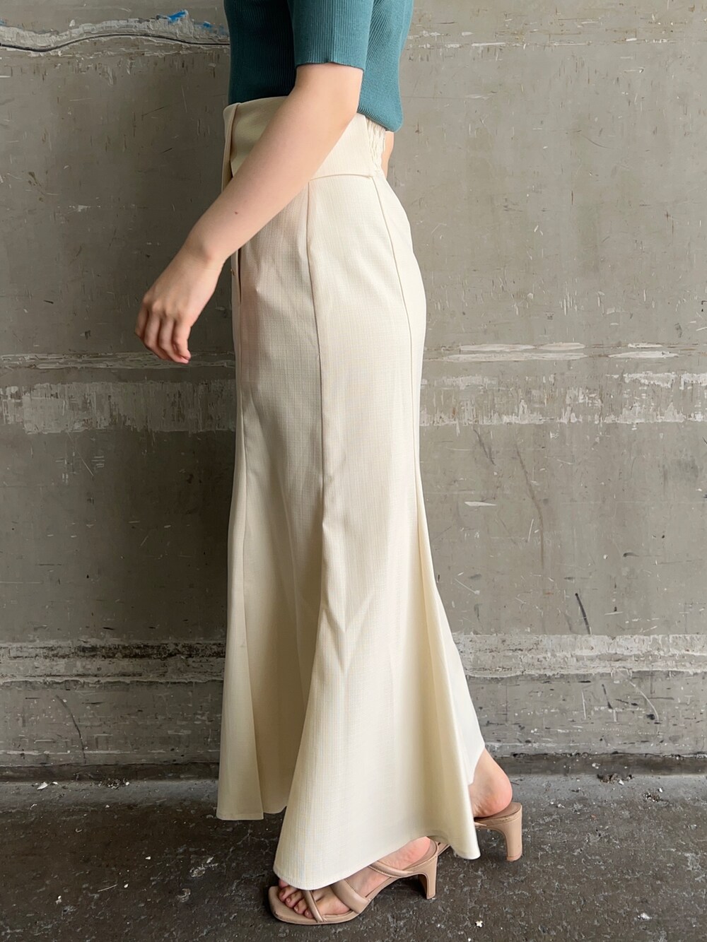 ホワイト系のハンドバッグ、グリーン系のニット/セーター、ホワイト系のスカートを着用したレディースの夏コーディネートの7枚目の写真