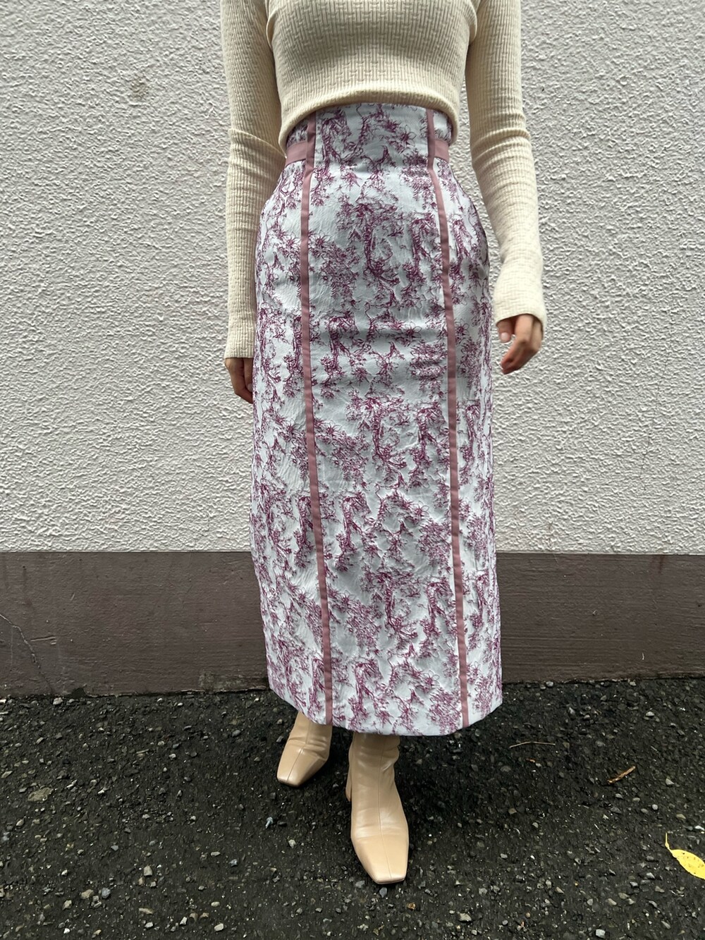 ベージュ系のブーツ、ベージュ系のその他アウター、ホワイト系のニット/セーターを着用したレディースの秋コーディネートの9枚目の写真