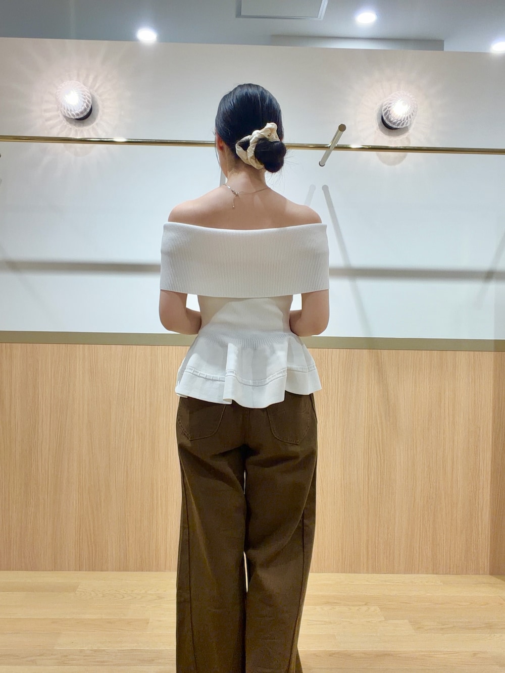 ブラウン系のデニムパンツ、ホワイト系のニット/セーター、ブラウン系のサンダルを着用したレディースの夏コーディネートの6枚目の写真