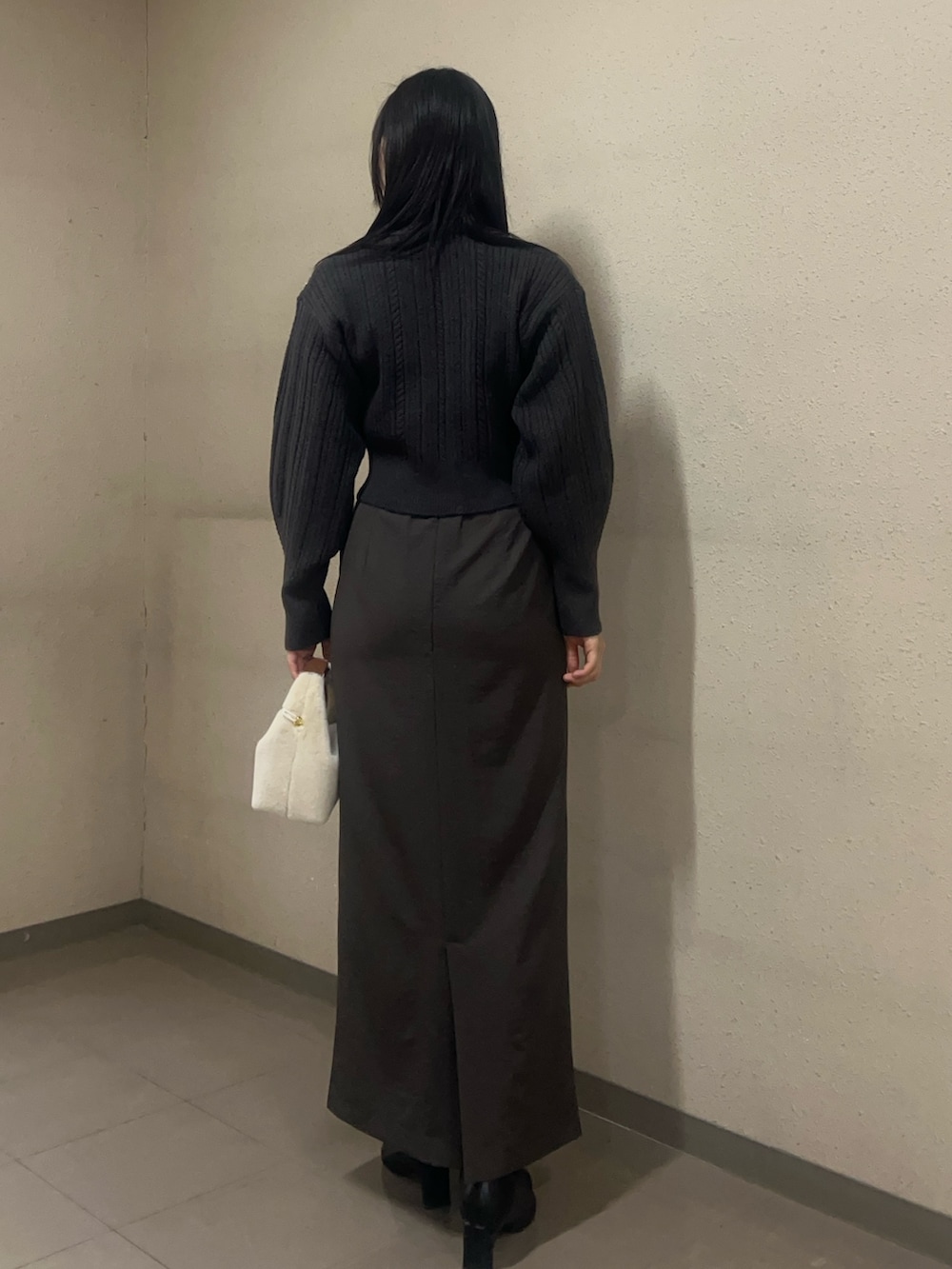 ブラック系のブーツ、グレー系のニット/セーター、ブラウン系のスカートを着用したレディースの秋コーディネートの3枚目の写真