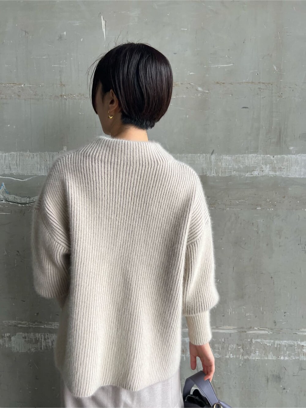 レッド系のブーツ、グレー系のスカート、パープル系のハンドバッグを着用したレディースの秋コーディネートの7枚目の写真