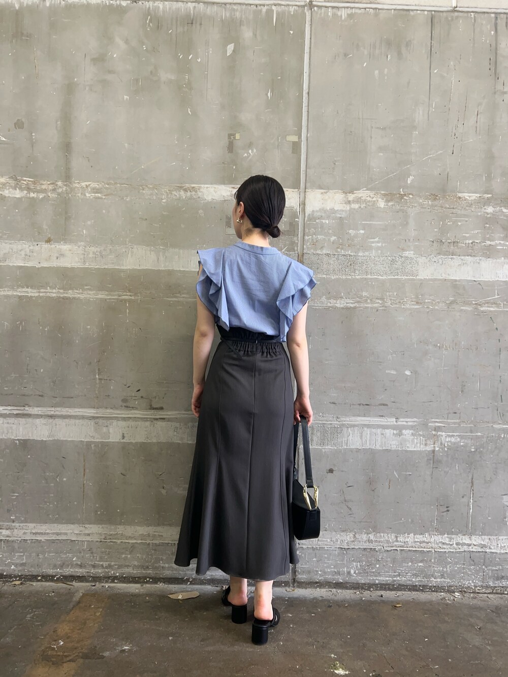 ブラック系のサンダル、ブラック系のショルダーバッグ、グレー系のスカートを着用したレディースの夏コーディネートの3枚目の写真