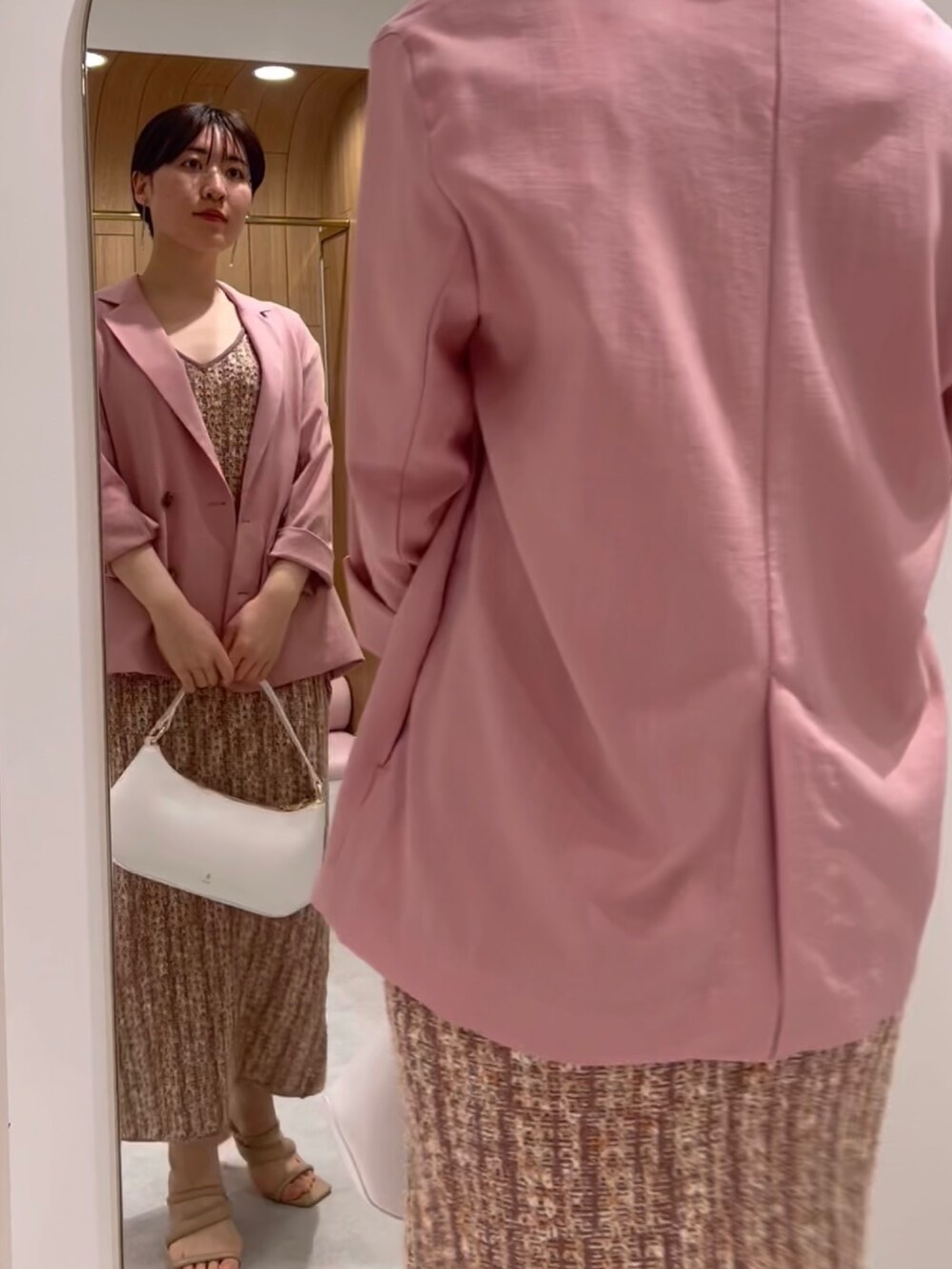 ベージュ系のサンダル、ピンク系のワンピース、ピンク系のテーラードジャケットを着用したレディースの春コーディネートの2枚目の写真