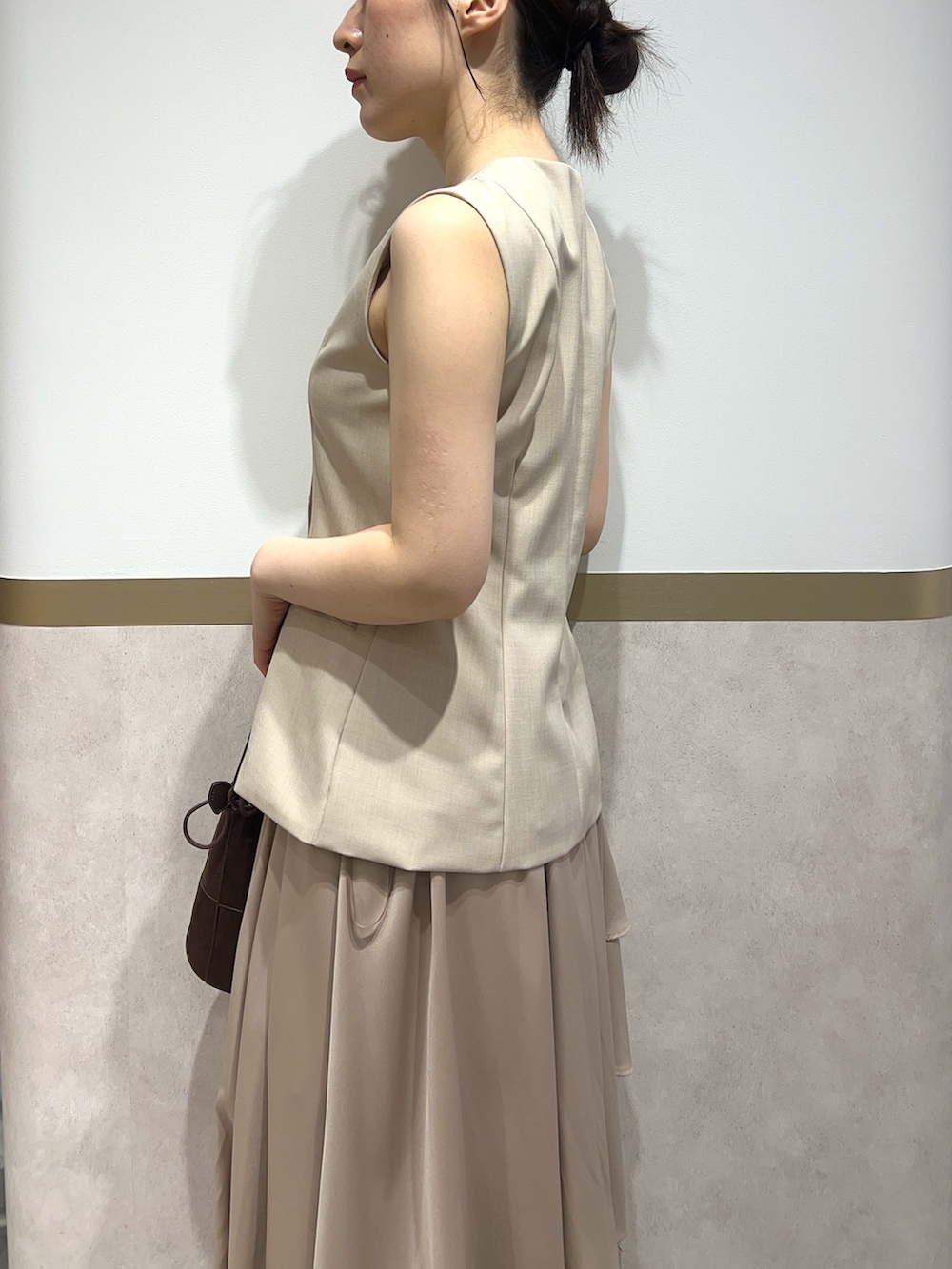 ベージュ系のワンピース、ブラック系のパンプス、ブラウン系のハンドバッグを着用したレディースの春コーディネートの5枚目の写真