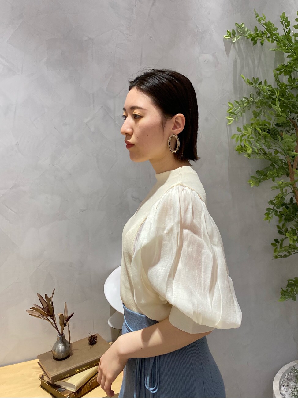 ブルー系のスカート、ホワイト系のニット/セーター、ベージュ系のサンダルを着用したレディースの春コーディネートの5枚目の写真