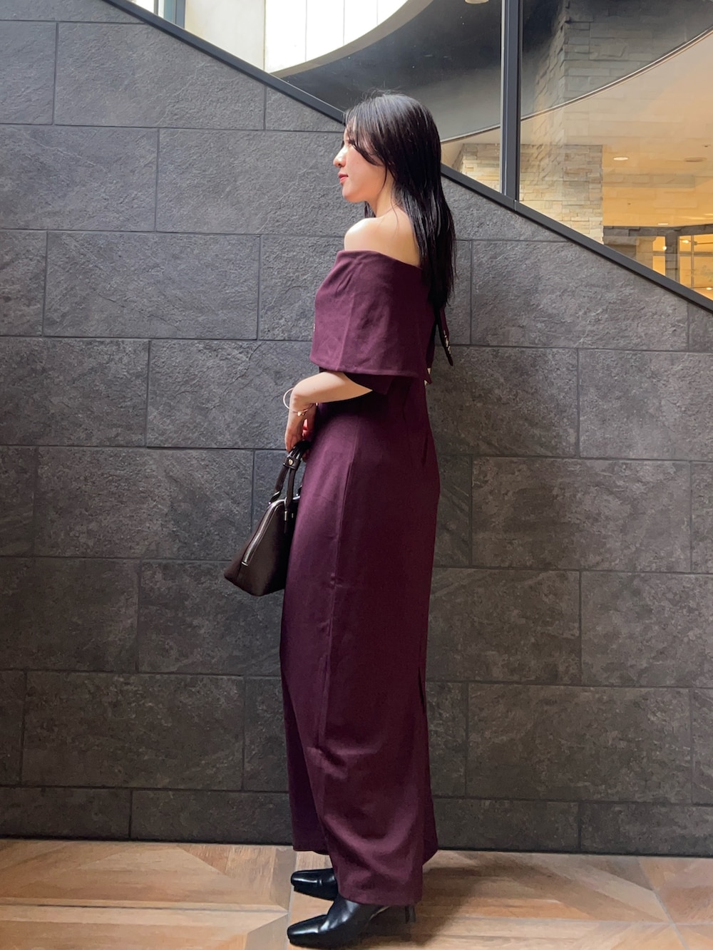 ブラウン系のボストンバッグ、ブラウン系のワンピース、ブラック系のブーツを着用したレディースの夏コーディネートの2枚目の写真