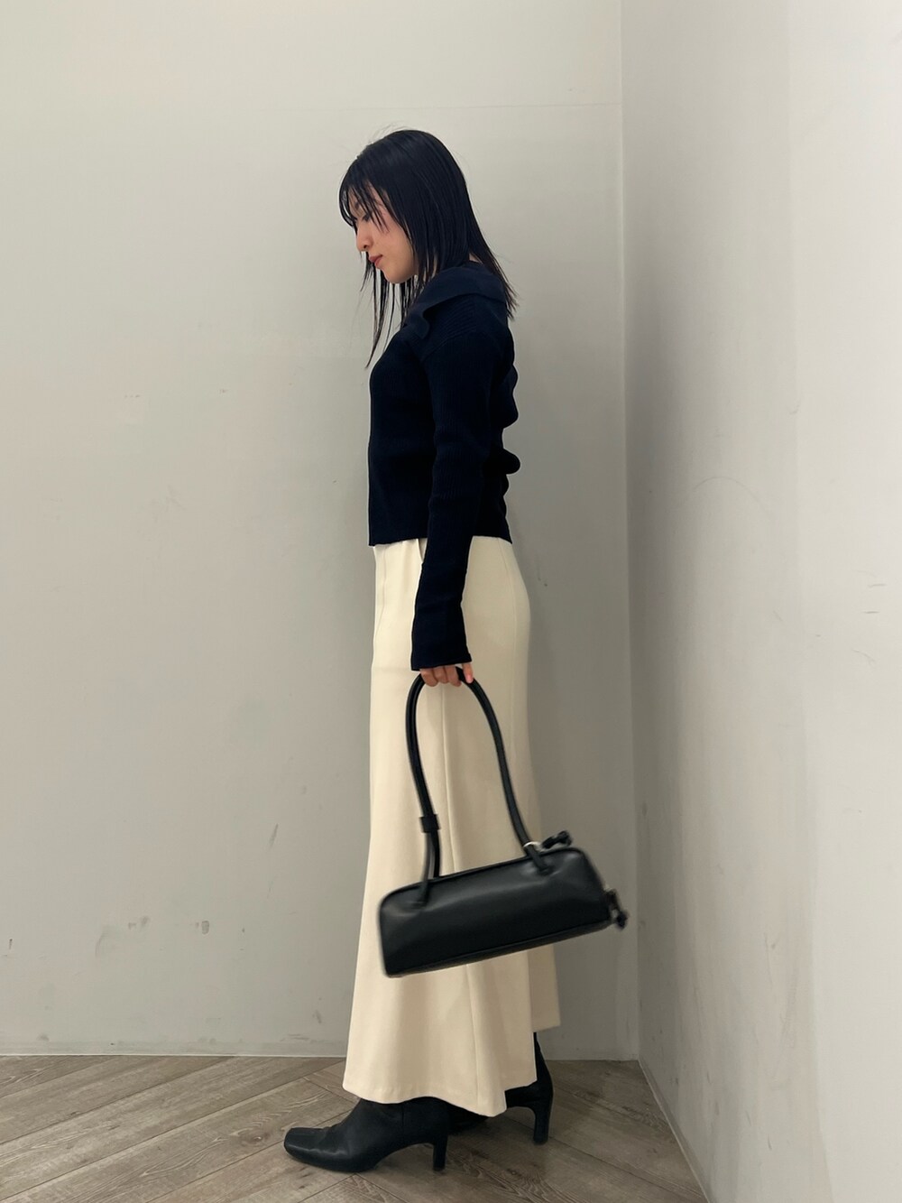 ブルー系のアンサンブル、ホワイト系のスカートを着用したレディースの冬コーディネートの2枚目の写真