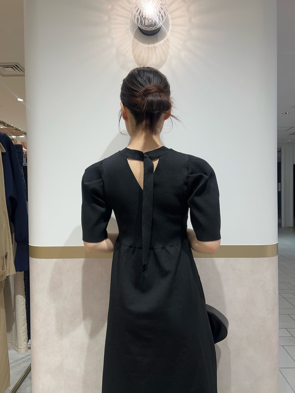 ブラック系のワンピース、ブラウン系のスニーカーを着用したレディースの春コーディネートの6枚目の写真