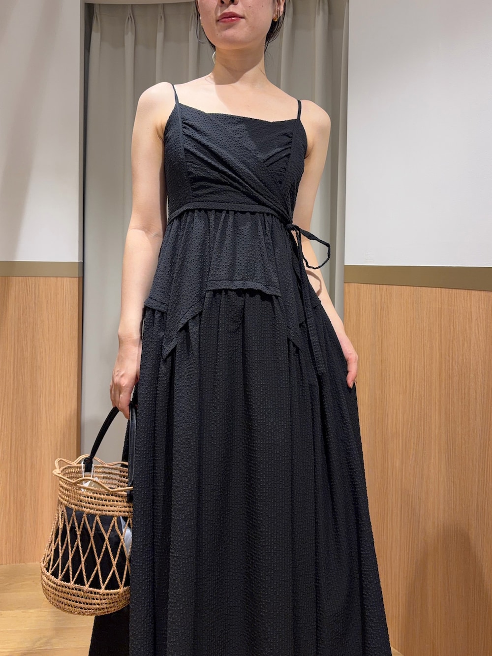 ブラック系のワンピース、ブラウン系のサンダル、ブラック系のハンドバッグを着用したレディースの夏コーディネートの4枚目の写真