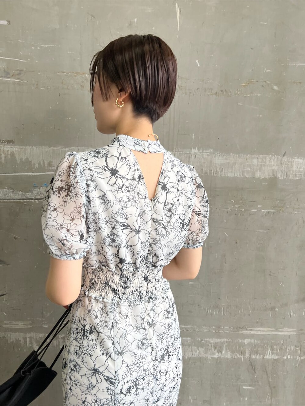 ブラック系のハンドバッグ、その他のパンプス、ホワイト系のワンピースを着用したレディースの春コーディネートの6枚目の写真