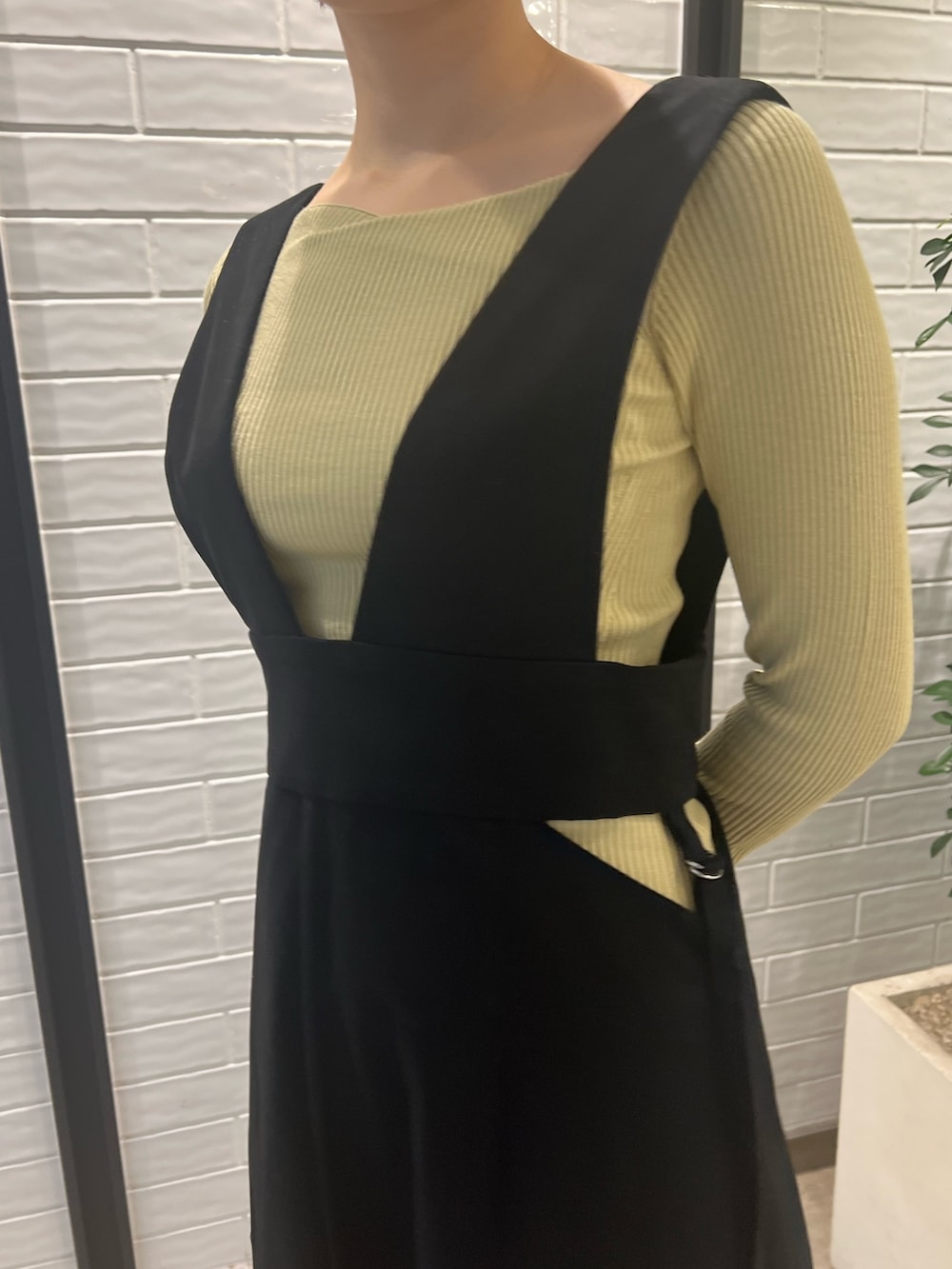 ベージュ系のブーツ、グリーン系のニット/セーター、ベージュ系のハンドバッグを着用したレディースの冬コーディネートの4枚目の写真